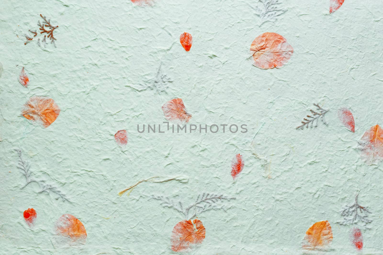Abstract texture background. Handmade wrinkled paper with pieces of leaves.