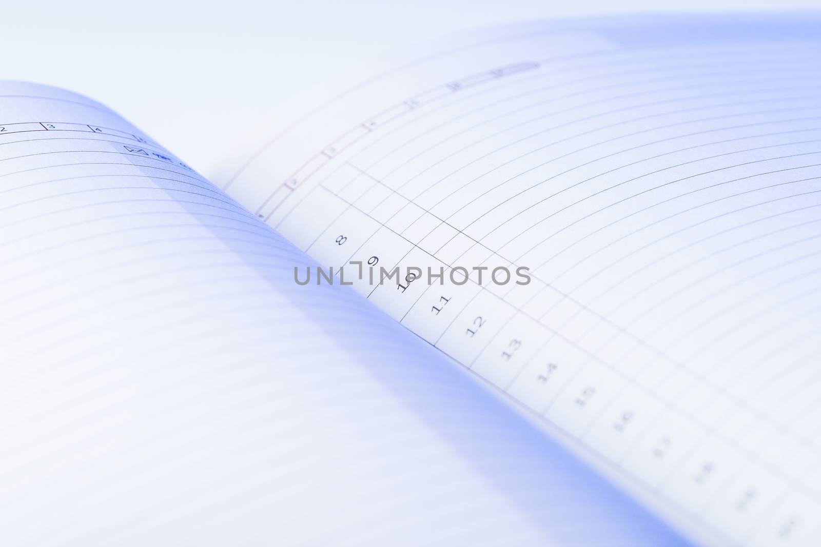 Clear pages of undated diary. Blue light falls on the numbered lines of daily planner. To do list.
