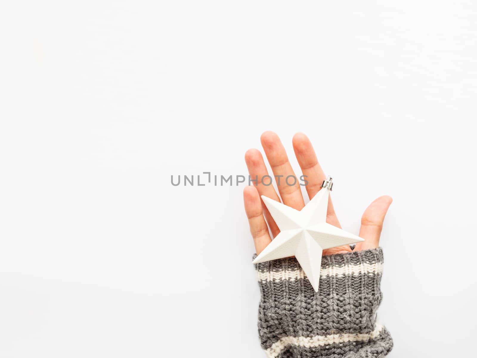 Woman is holding New Year decoration - two stars on white background. Top view on decoration for Christmas tree.