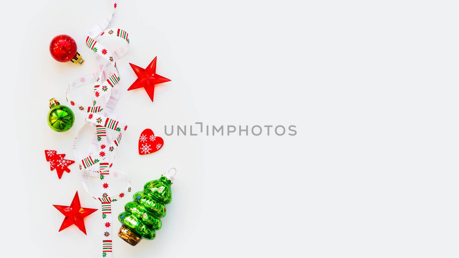 Ribbon with Christmas pattern - nordic geometric snowflakes. New Year decorations - bright colorful balls, fir tree, star. Place for text. Flat lay, top view.