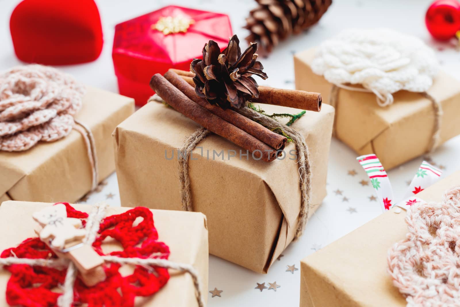 Christmas and New Year background with presents and decorations. Hand made gift wrapped in craft paper with pine cone and cinnamon.