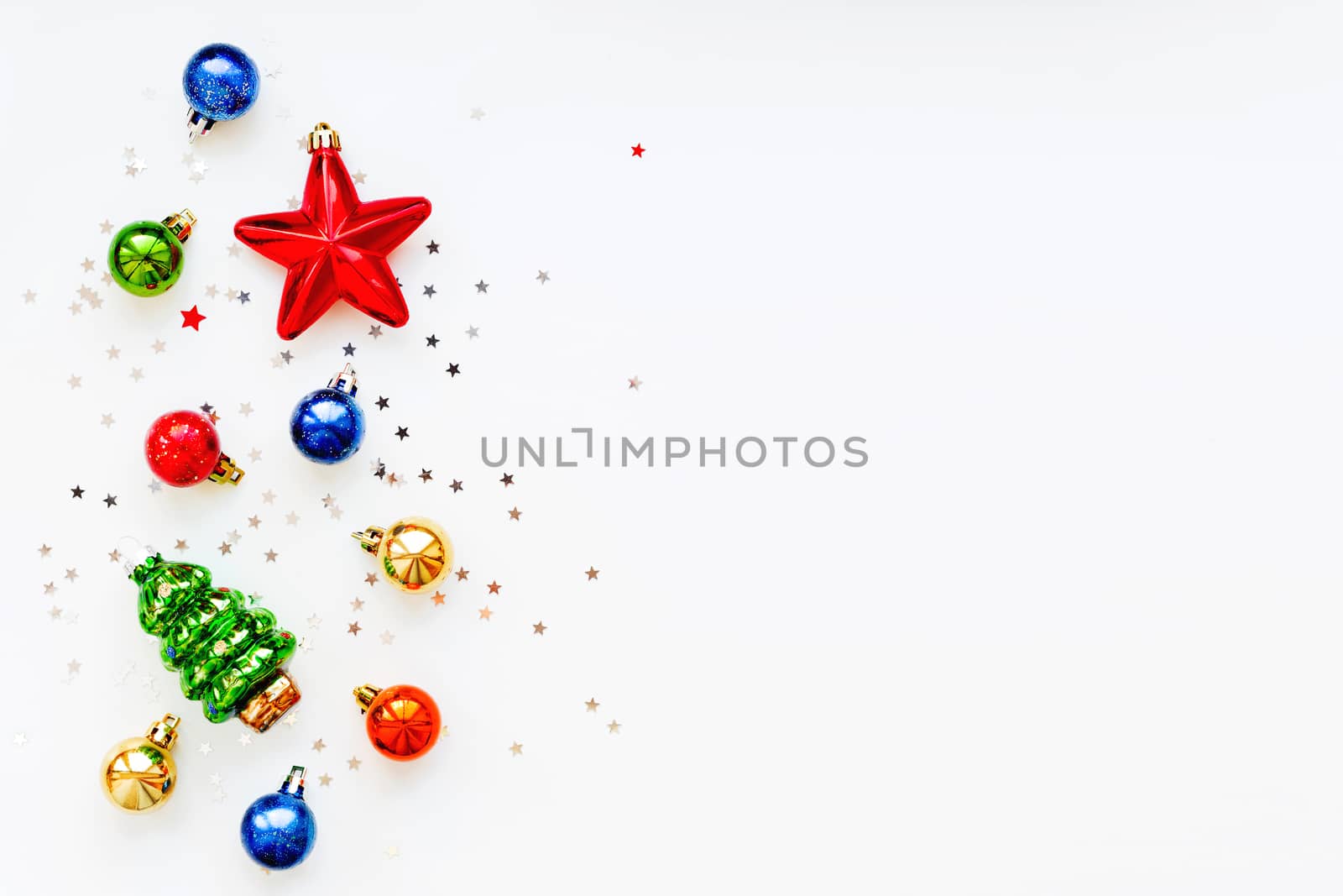 Christmas background with decorations. New Year symbol - fir tree. Shiny colorful balls, star and confetti. Flat lay, top view. Place for text.