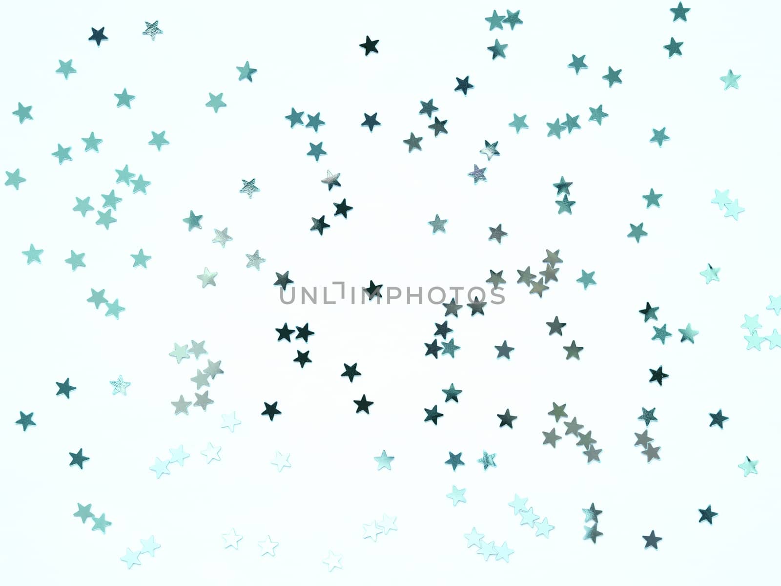 Holiday background with silver star confetti on mint colored background. Good backdrop for Christmas and New Year cards. Flat lay, top view.