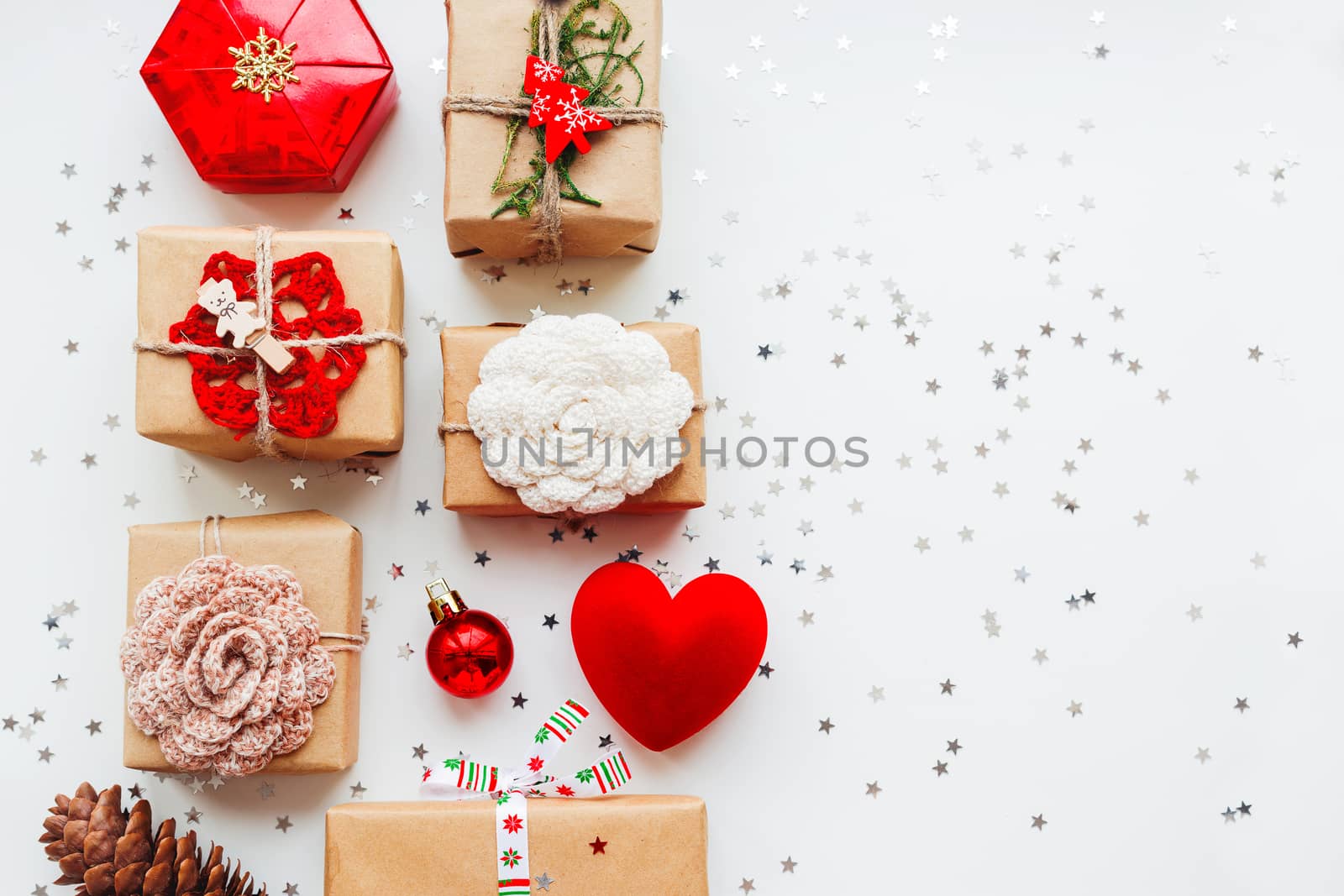 Christmas and New Year background with presents and decorations - red heart, craft paper, handmade crocheted flowers and symbols of holiday. Place for text.