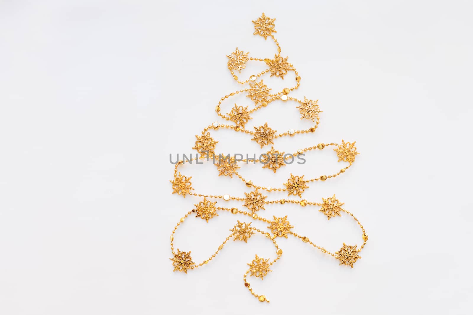 Christmas Tree made of golden snowflake garland. New Year symbol with place for text. Flat lay, top view.
