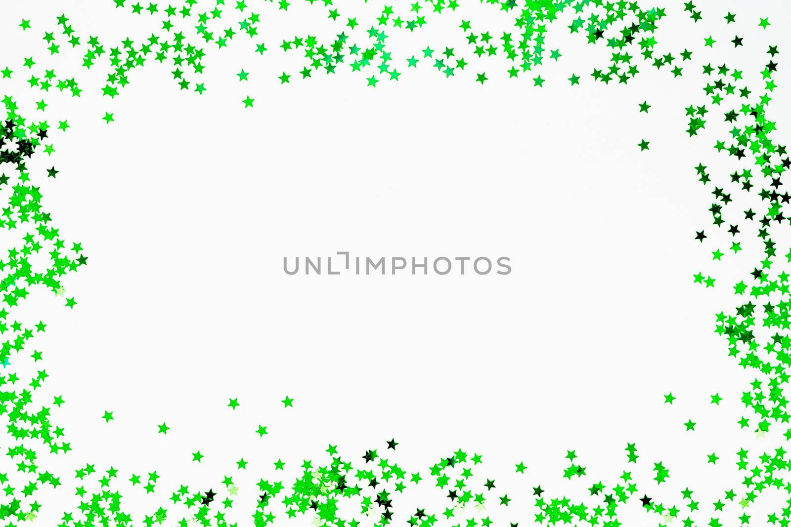 Holiday background with frame of green star confetti. Good background for Christmas and New Year cards.