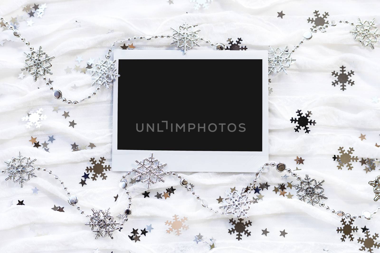 Winter background with decorative sparkling snowflakes. Empty photo frame for your picture or text.