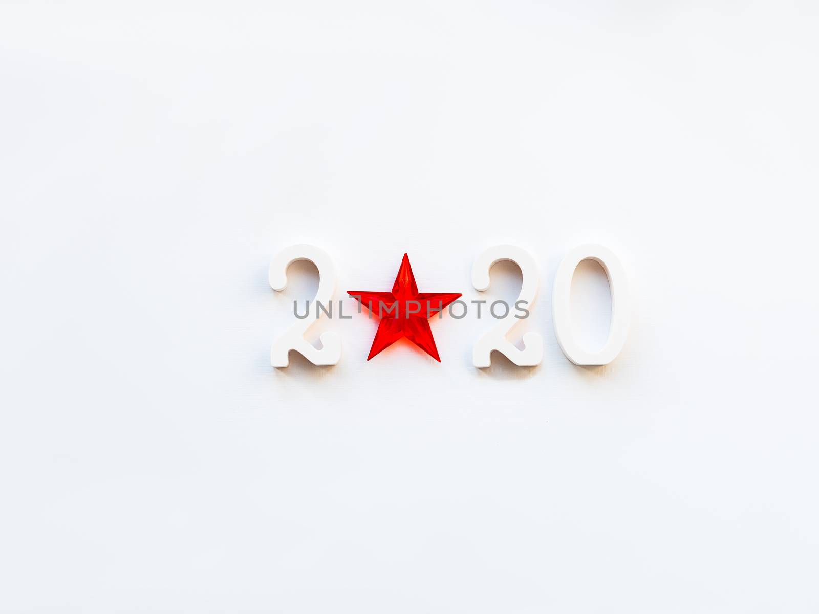 New Year 2020 background with bright red star. Numbers 2020 on white copy space with decorative ball for Christmas tree.