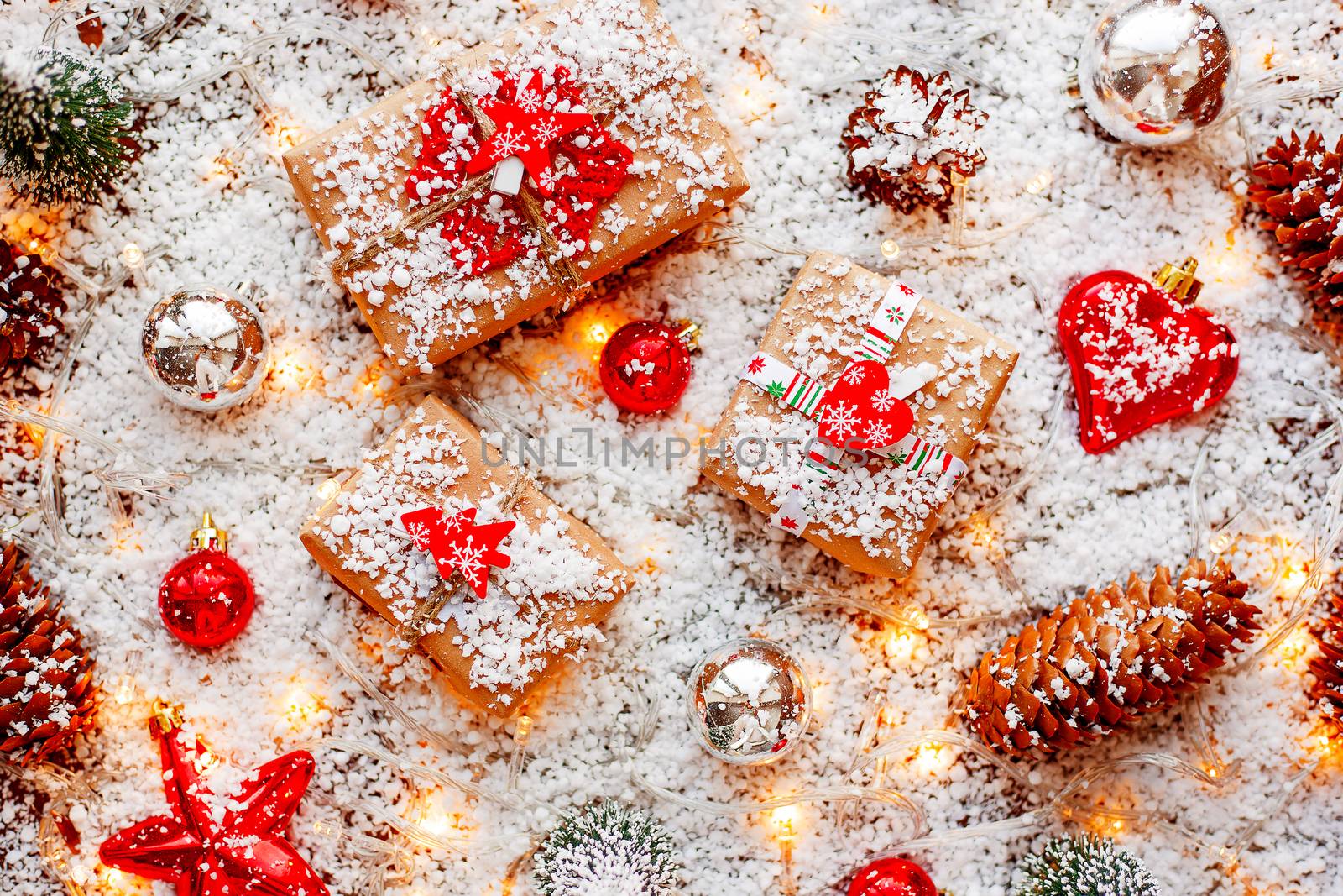 Christmas and New year background with presents, ribbons, balls and different decorations in snow with light bulbs.