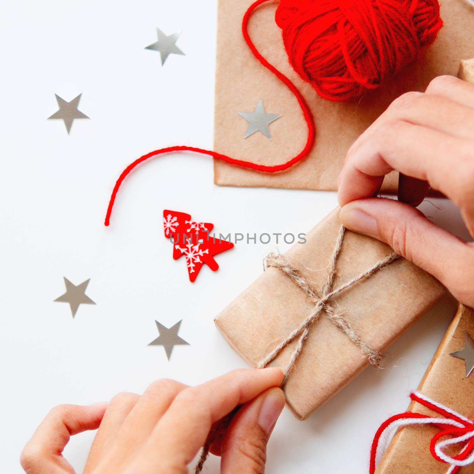 Woman is packing Christmas and New Year DIY presents in craft pa by aksenovko