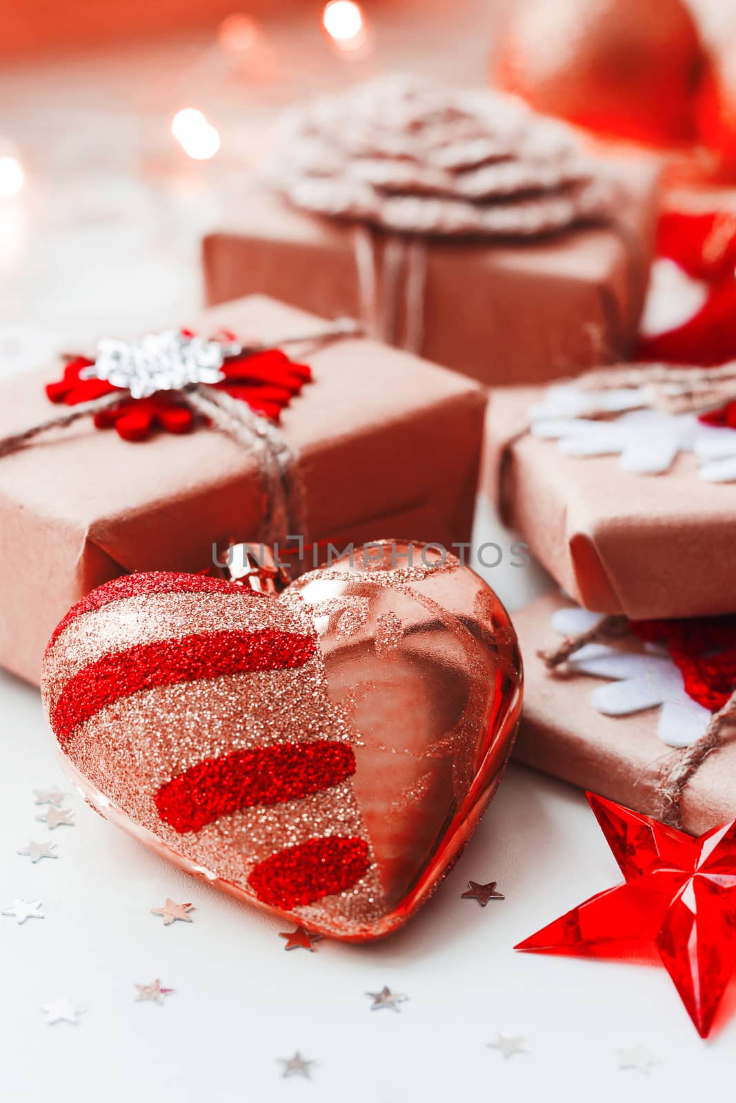 Christmas and New Year background with presents and decorative heart for Christmas tree. Holiday background with stars confetti and light bulbs.