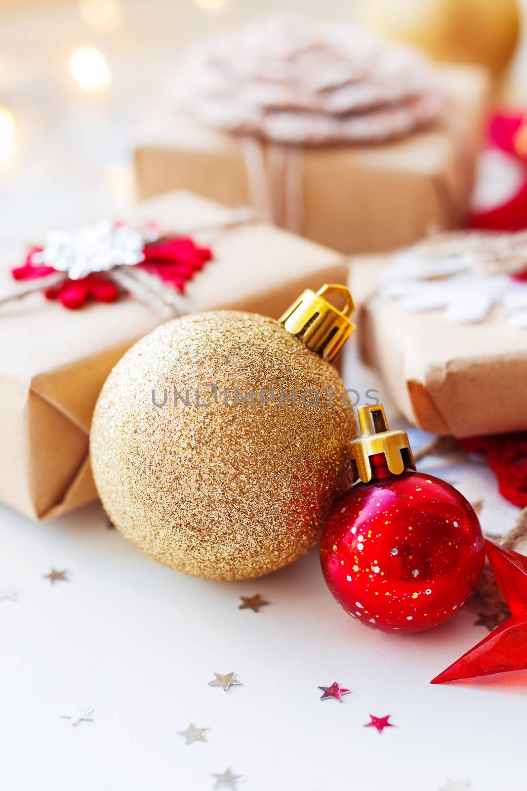 Christmas and New Year background with golden decorative ball, presents and decorations for Christmas tree. Holiday background with stars confetti and light bulbs. Place for text.