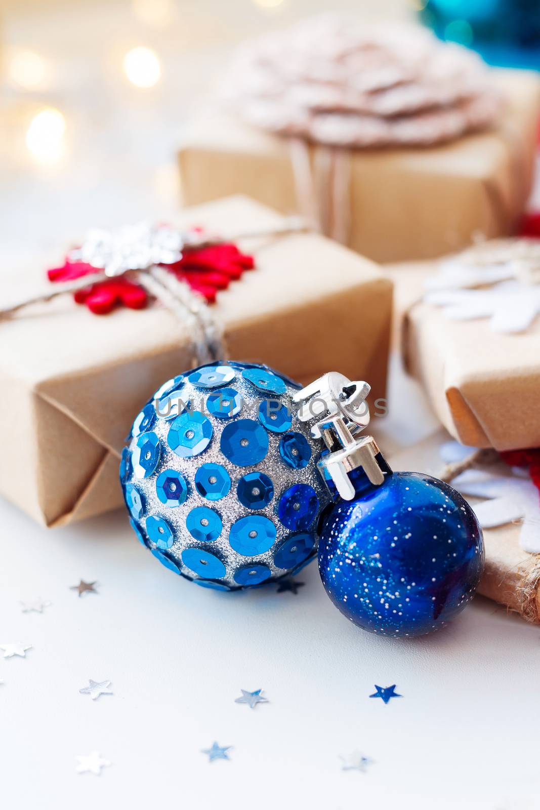 Christmas and New Year background with blue decorative balls, presents and decorations for Christmas tree. Holiday background with stars confetti and light bulbs. Place for text.