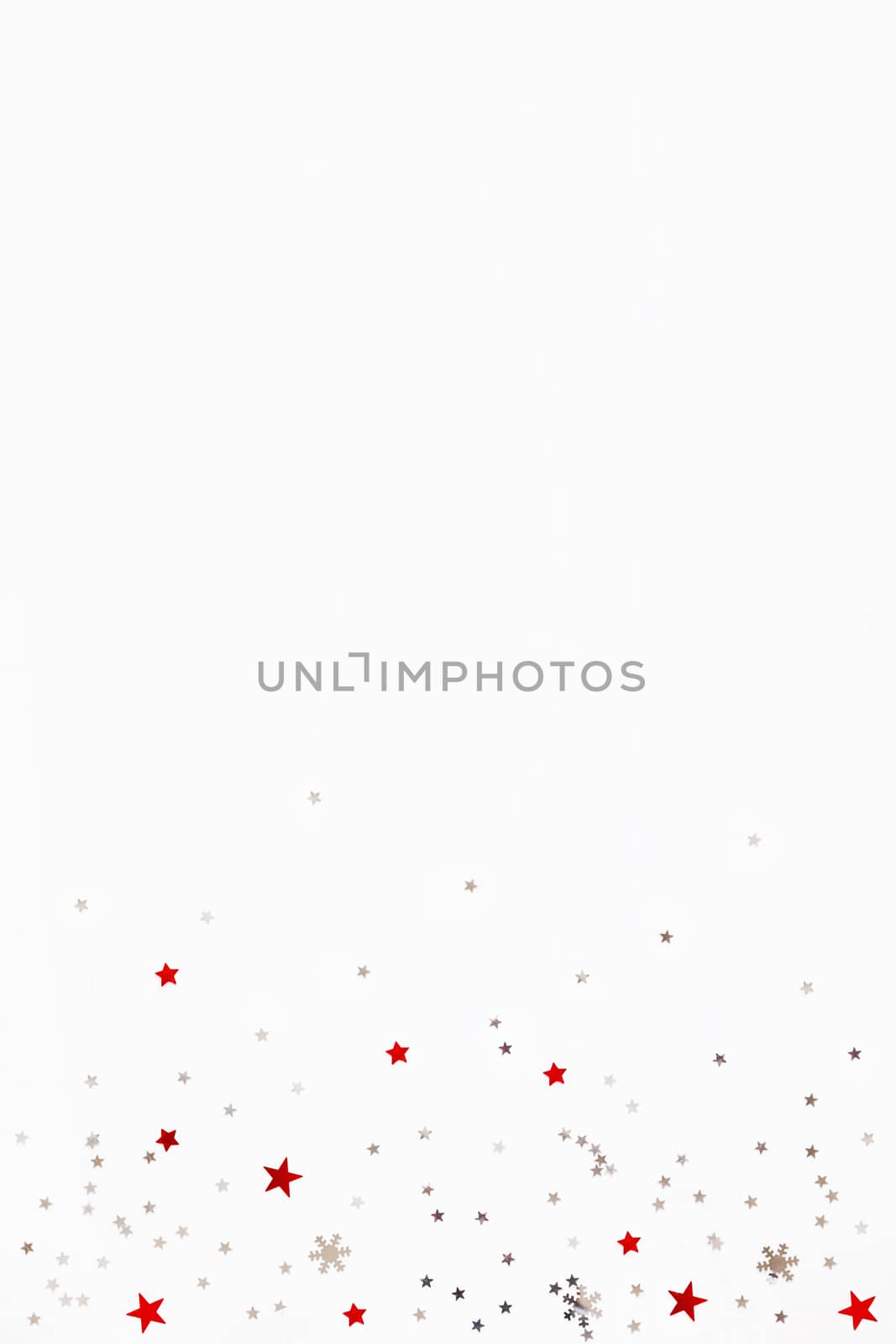 Christmas and New Year background with sparkling red and silver stars confetti. Flat lay, top view. Place for text.