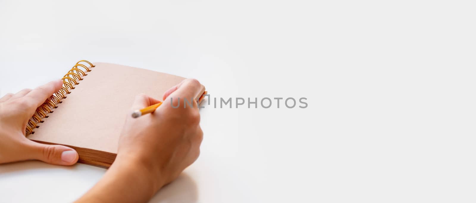 Woman is preparing to write or draw something in notepad with craft paper pages. Banner with copy space.
