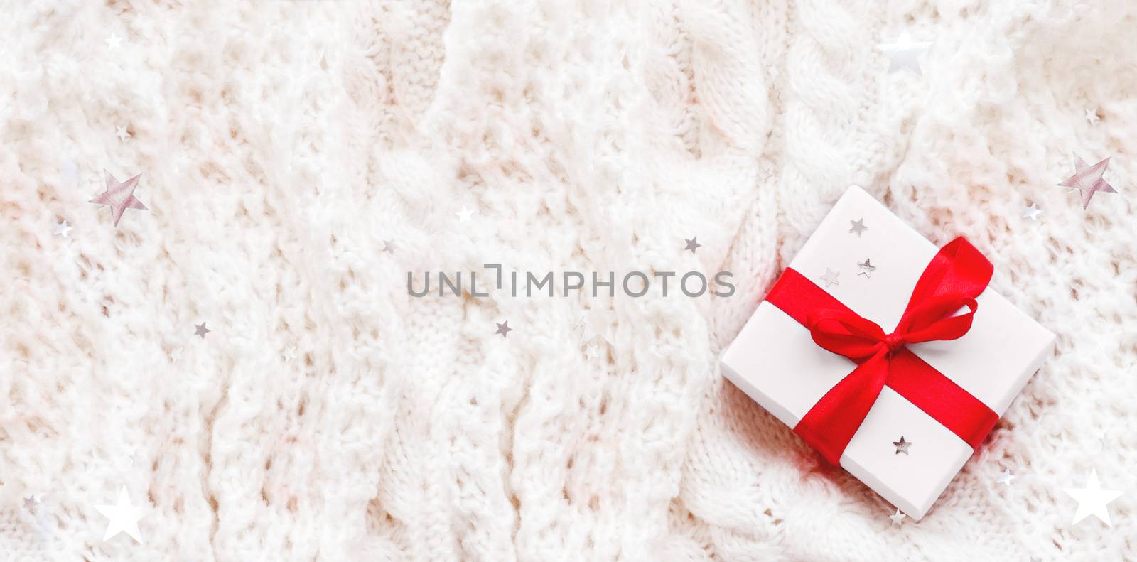 Present in white wrapping paper on white knitted backdrop. Holid by aksenovko