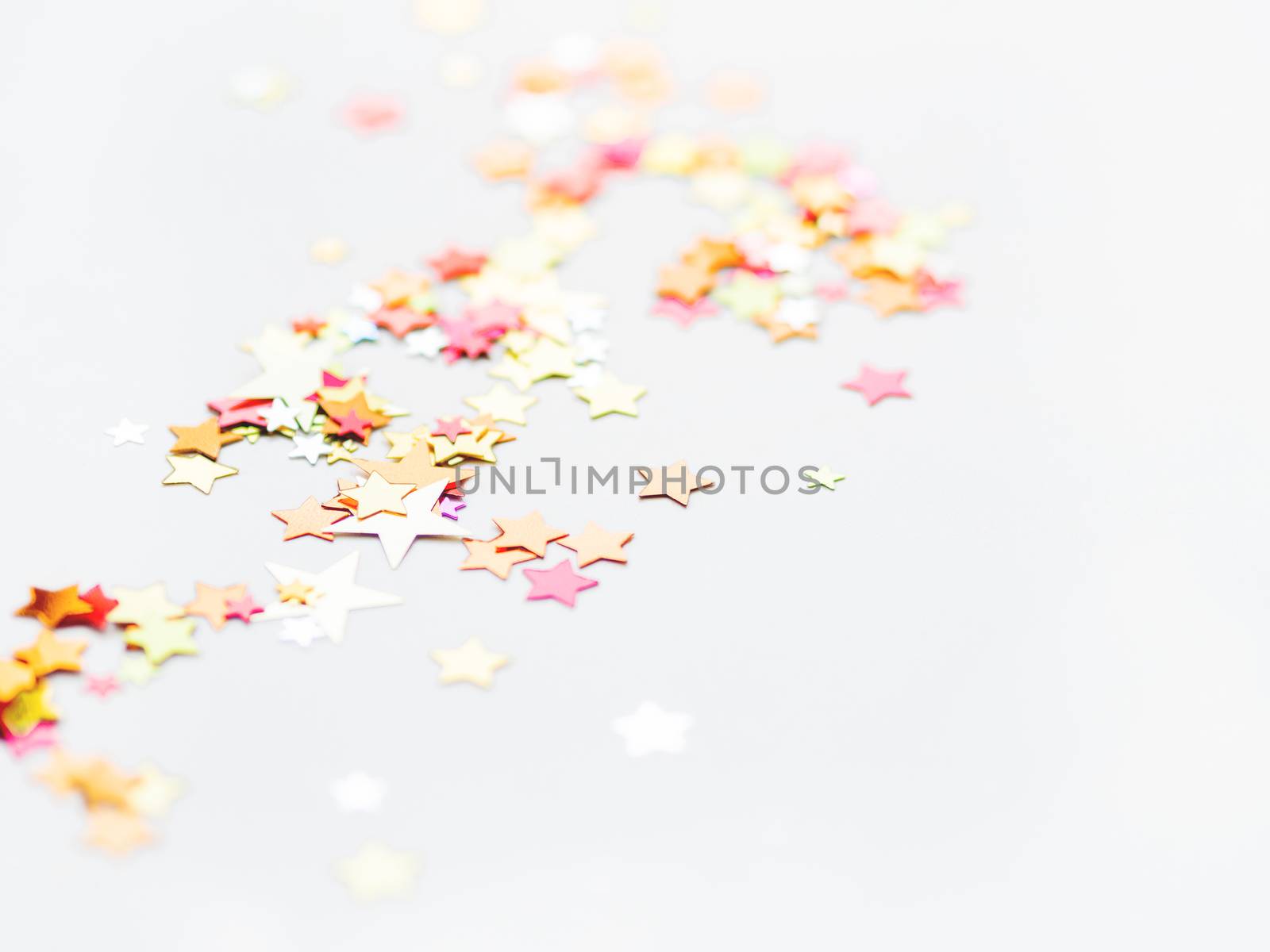 White holiday background with colorful star confetti. Good background for Christmas and New Year cards.
