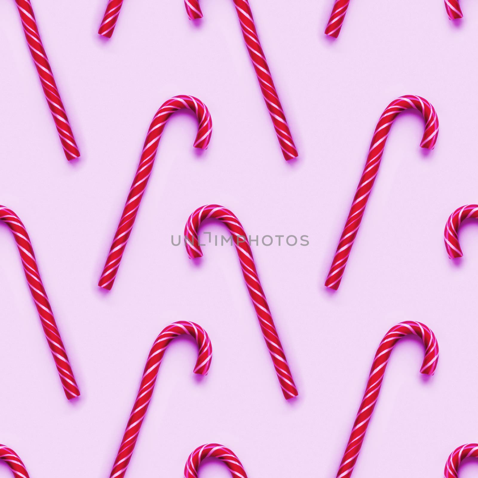 Seamless pattern of Christmas candy cone on magenta background. Colorful holiday sweet lollipop. Dessert wtih neon pink and white stripes.