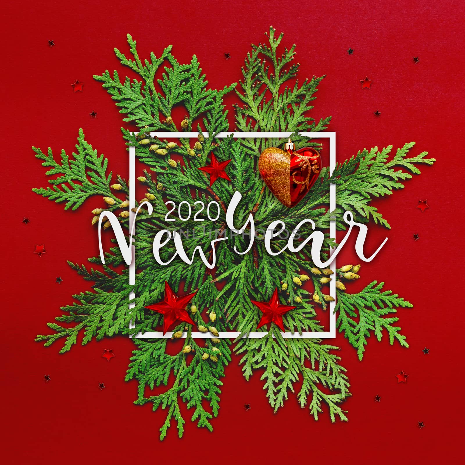 Christmas background with thuja branches and words NEW YEAR 2020 in white square frame. Trendy Xmas greeting with stars and ball decorations on red backdrop.