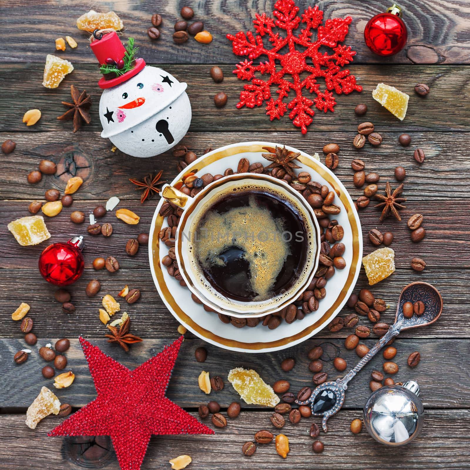 Rustic wooden background with cup of coffee and New Year decorations. White vintage dinnerware and spoon. Christmas beverage with ginger and anise. Top view