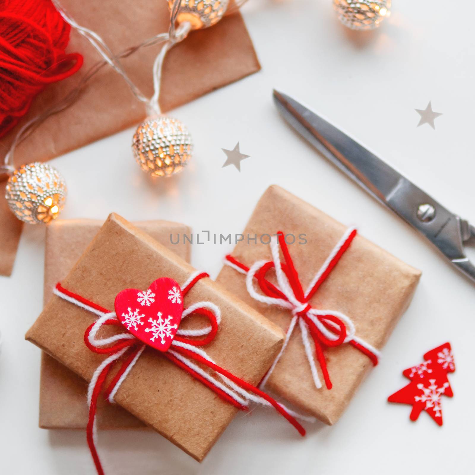 DIY presents wrapped in craft paper. Gifts tied with white and r by aksenovko