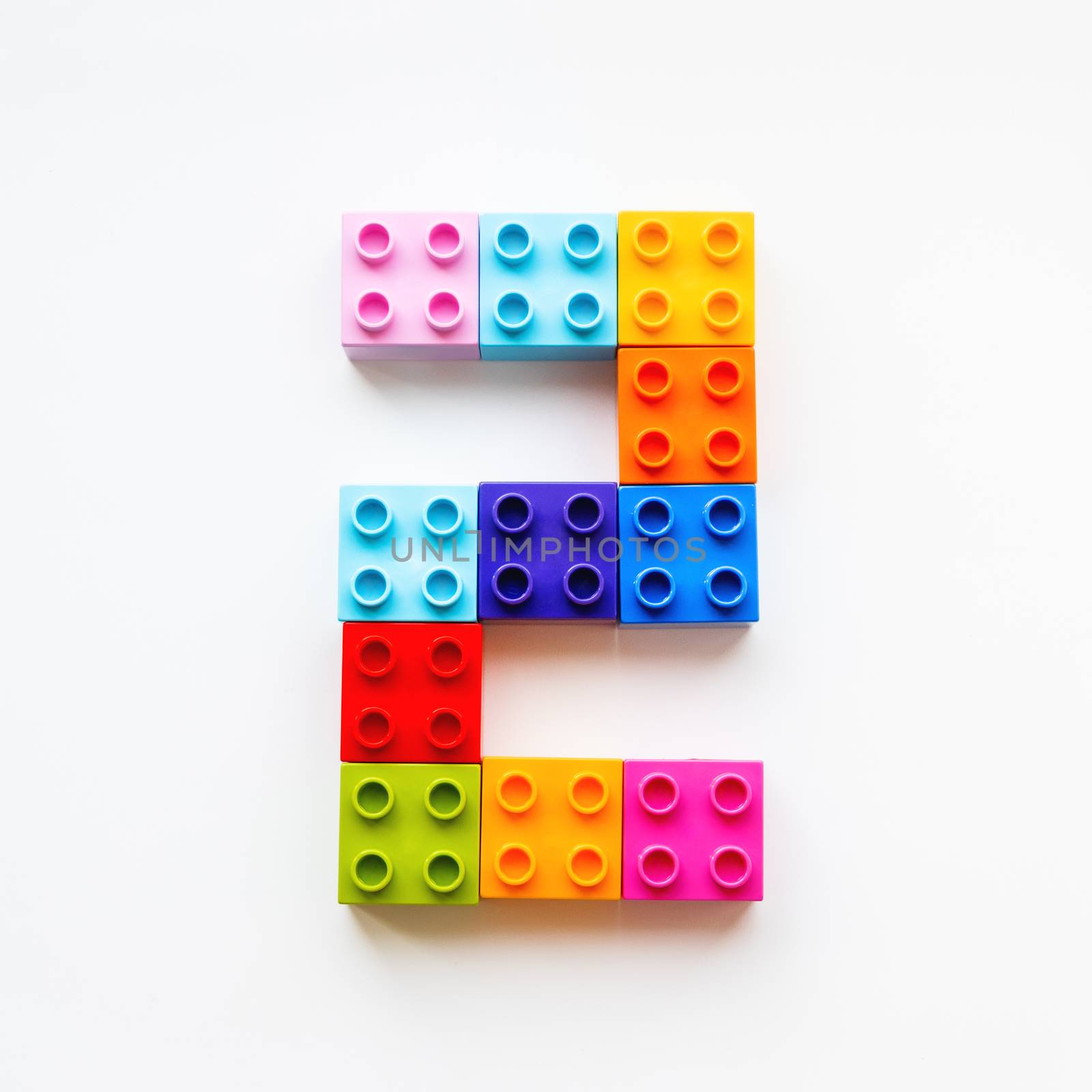 Number Two made of colorful constructor blocks. Toy bricks lying in order, making number 2. Education process - learning numbers with child using multicolored toy details.