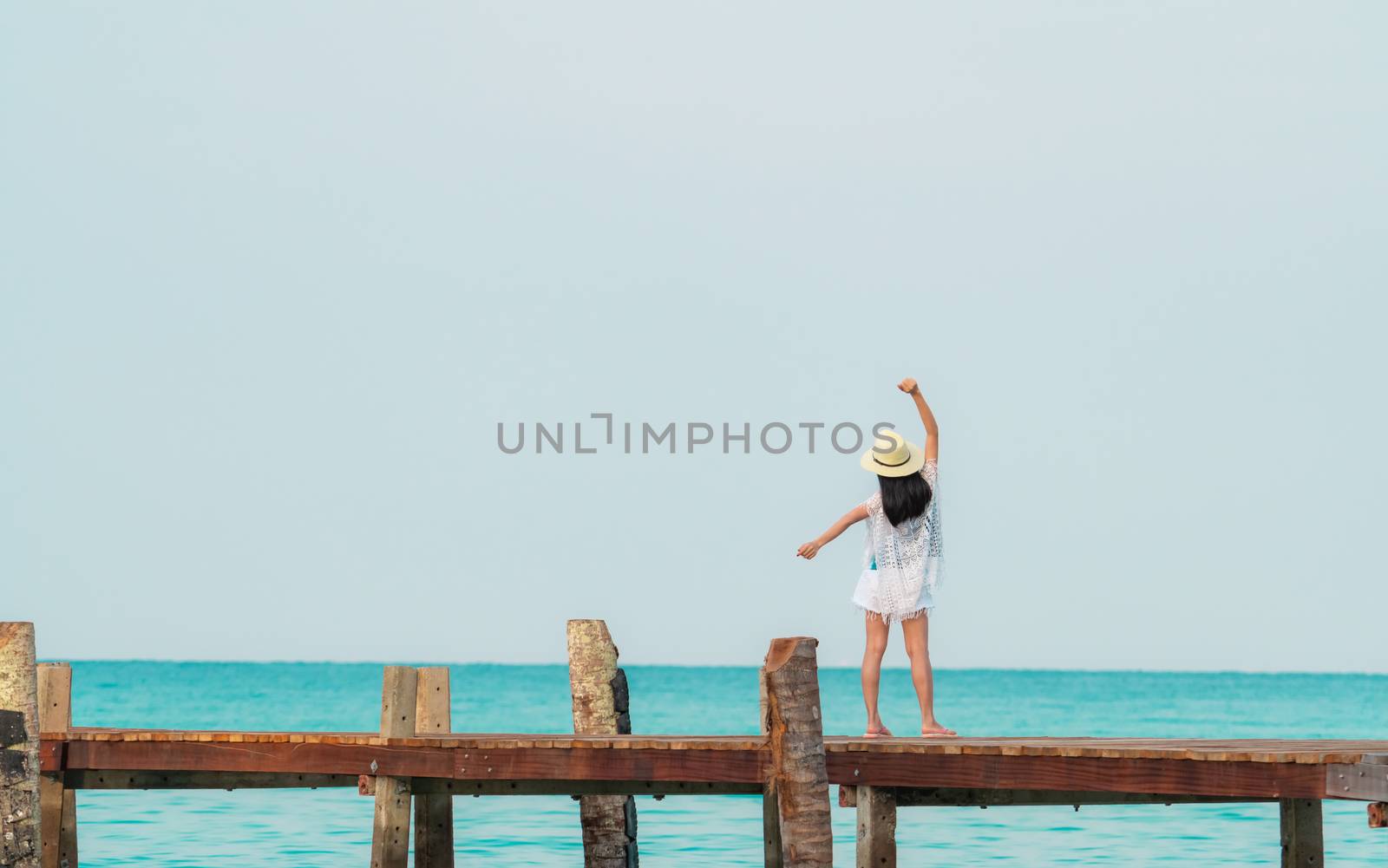 Back view of happy young Asian woman in casual style fashion and by Fahroni