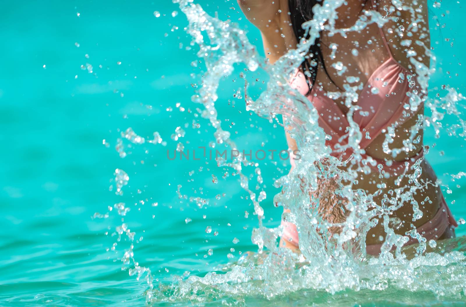 Happy young Asian woman in pink swimsuit relax and enjoy holiday by Fahroni