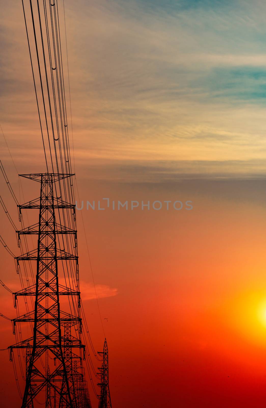 High voltage electric pole and transmission lines in the evening by Fahroni