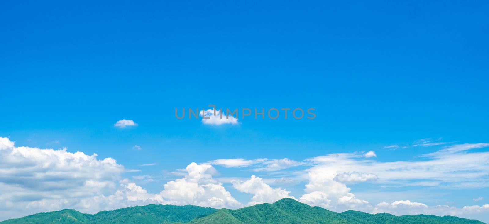 Blue sky and white cumulus clouds over green mountain. Beauty in by Fahroni