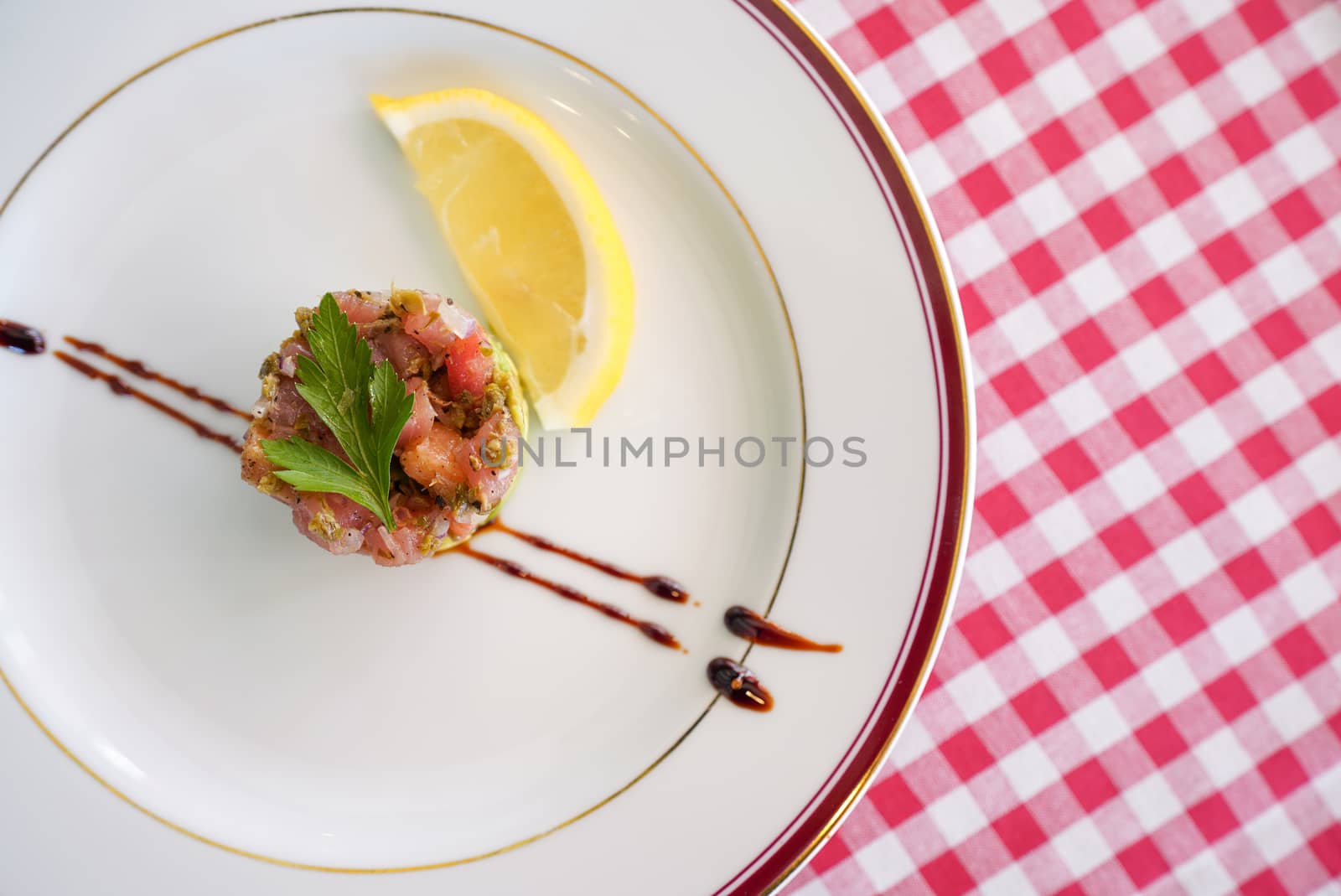 TARTARE DI TONNO O SALMONE. Finely diced tuna and salmon mixed with shallot, lemon juice, extra virgin olive oil and chopped herbs. Served with lettuce and balsamico reduction