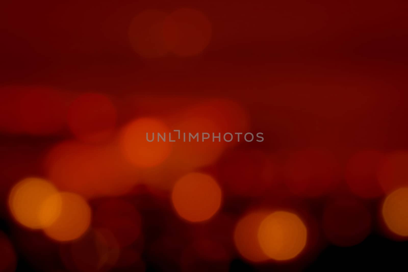 Blurred red and orange bokeh background. Blur abstract background of urban light. Warm light with beautiful pattern of round bokeh. Red light in the night. Street lamp blurred lights. Romantic night.