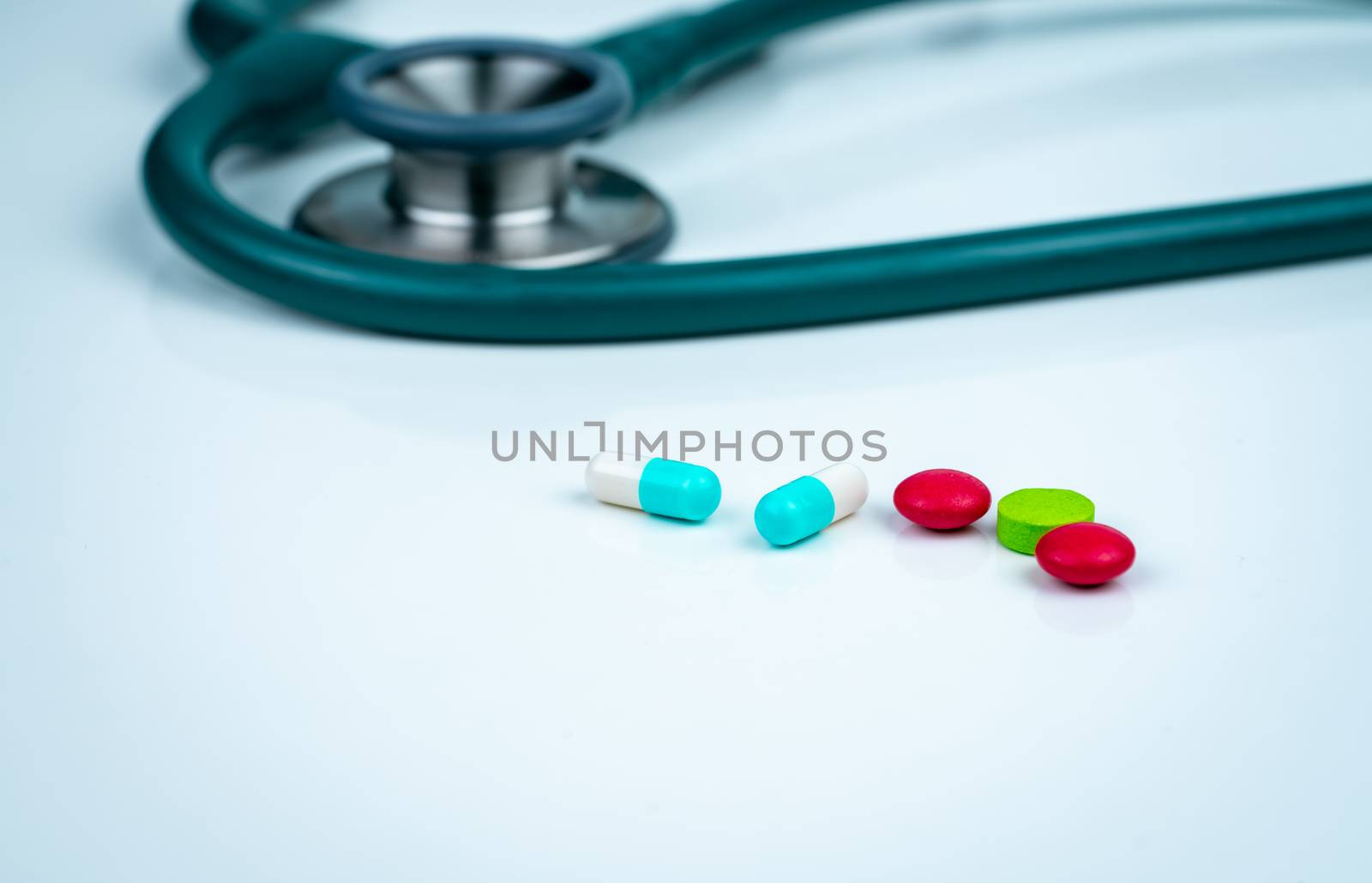 Stethoscope, capsule, and tablets pills on doctor table or nurse desk. Health checkup. Medical healthcare and medicine background. Physician tool for patient diagnosis. Cardiology doctor equipment.