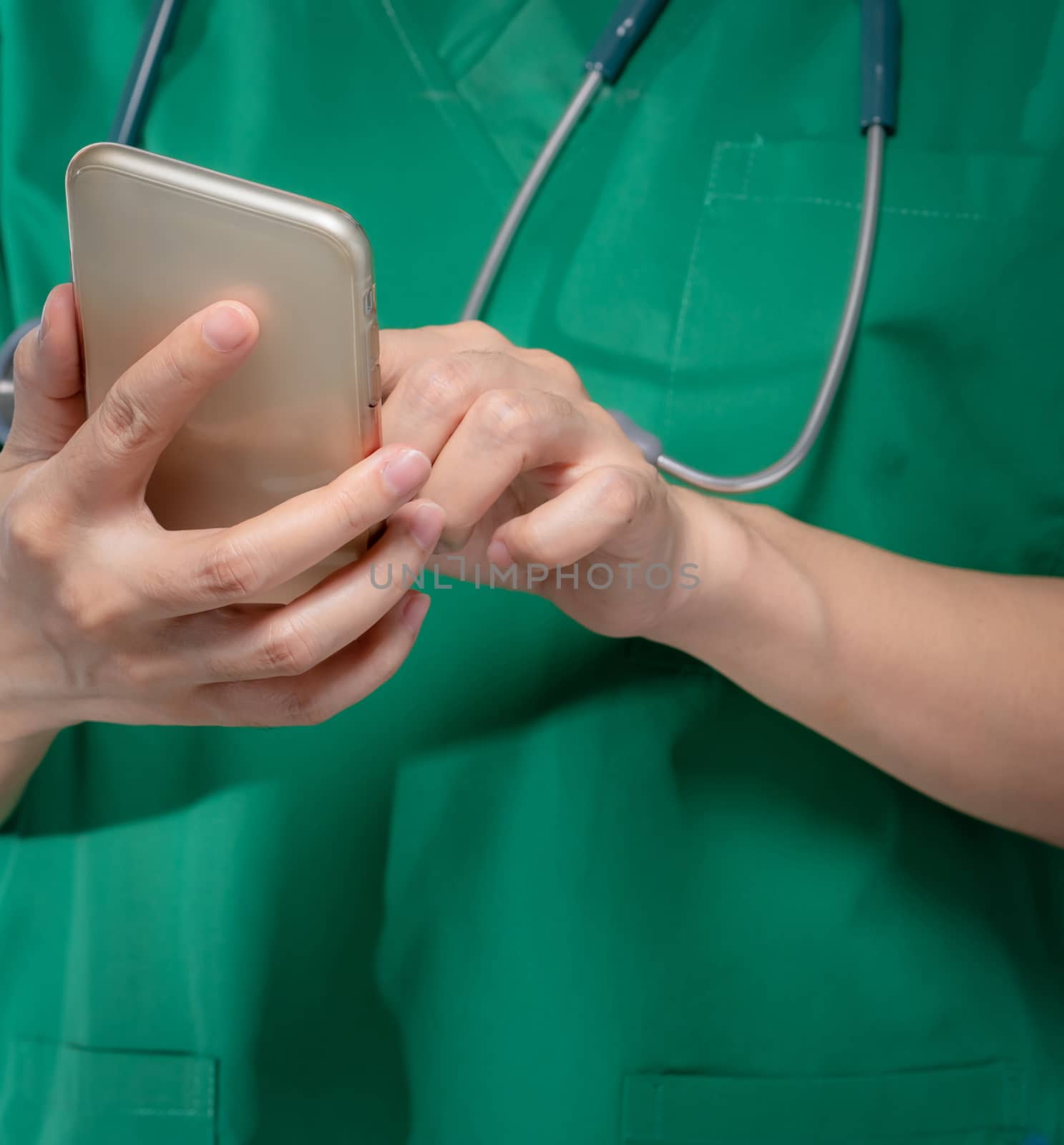 Doctor with stethoscope use mobile phone to communicate with healthcare providers or patient. Surgeon hand holding smartphone. Medical health application on mobile phone. Telemedicine concept.