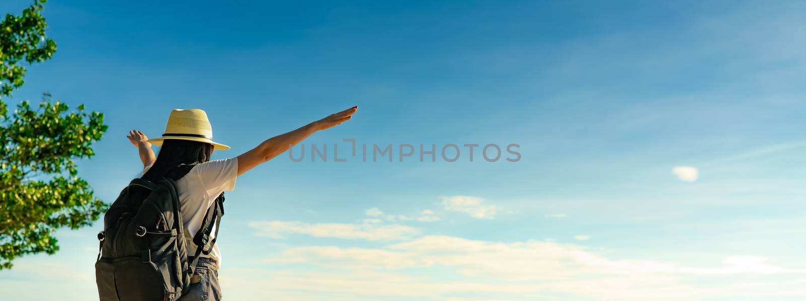 Back view of happy young Asian woman in casual style fashion with straw hat and backpack. Relax and enjoy holiday at tropical paradise beach. Summer vibes. Relaxing and enjoying at tropical beach.