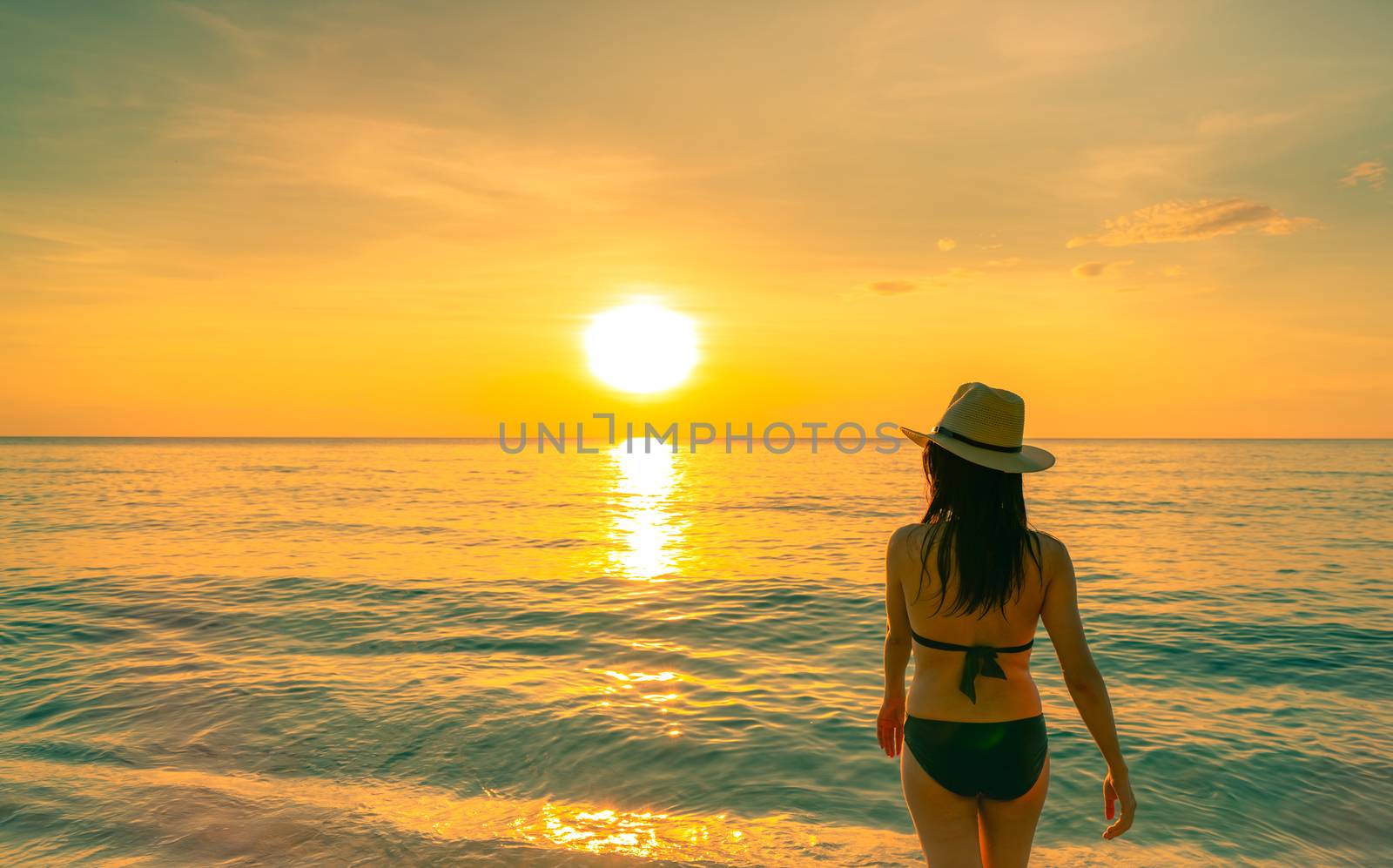 Silhouette adult woman walking at tropical sea with beautiful su by Fahroni