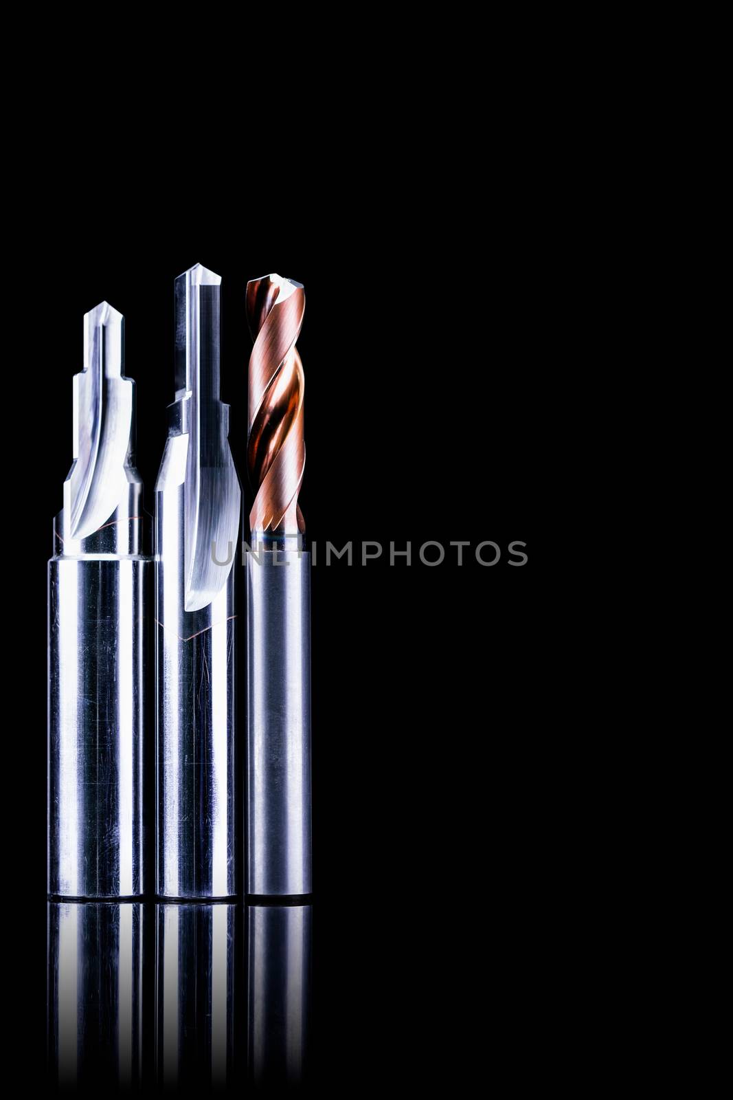 Special tools isolated on dark background. Made to order special tools. Coated step drill and reamer detail. HSS cemented carbide. Carbide cutting tool for industrial applications. Engineering tools.