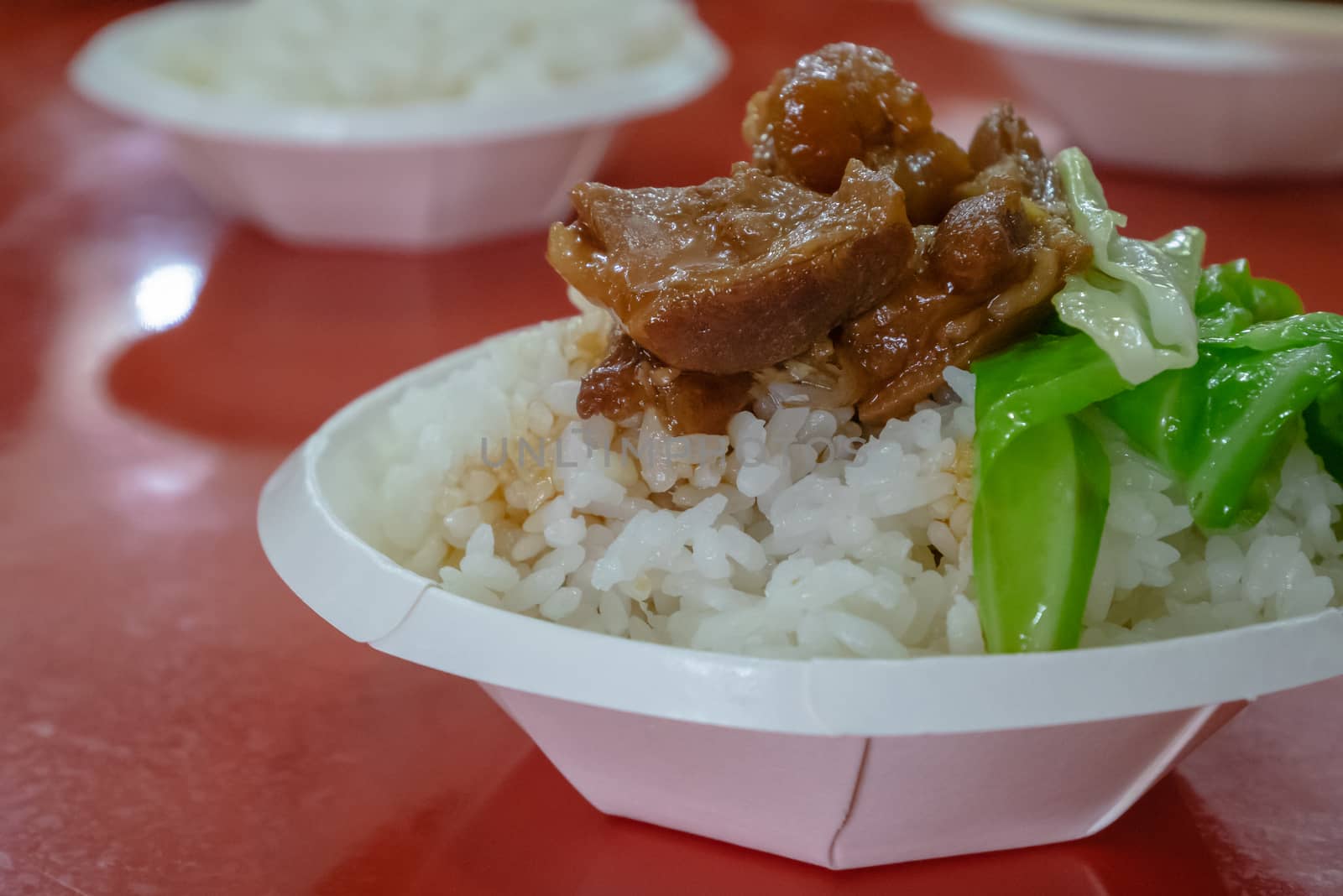 The close up of  Taiwanese pork knuckle rice food on paper cup at taiwan night market in Taipei, Taiwan.