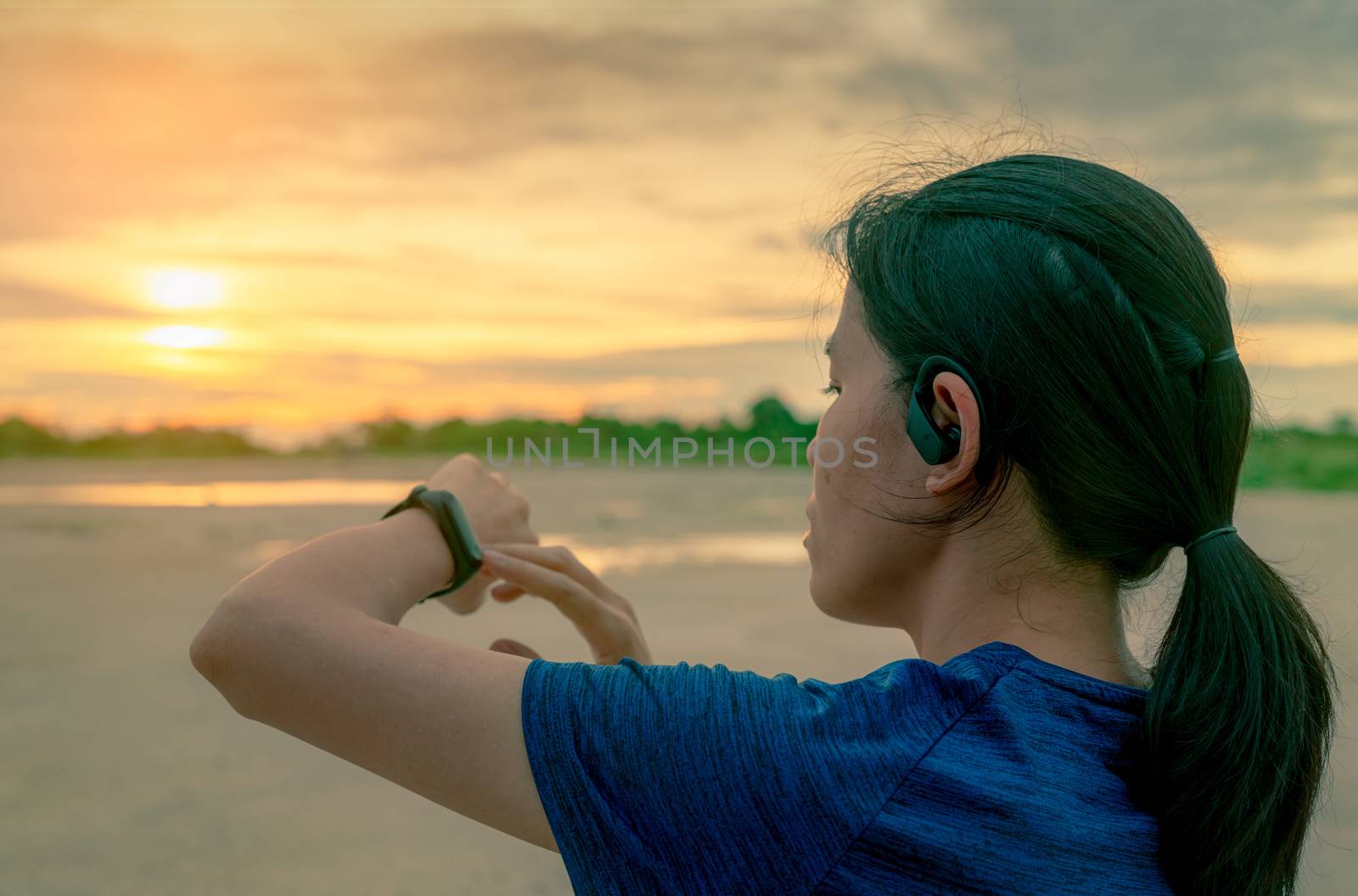 Asian woman wear in ear sport true wireless earbuds touching sma by Fahroni