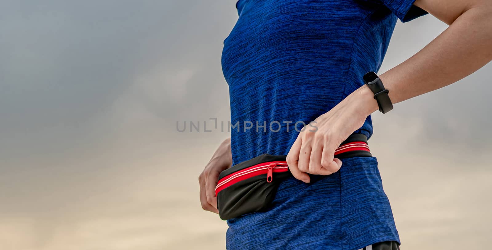 Young Asian woman wear wristband and waist belt. Running cardio  by Fahroni