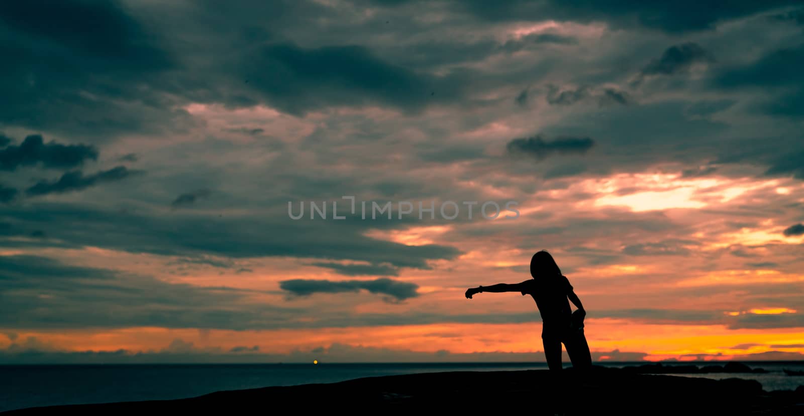 Silhouette woman workout in the morning at stone beach with beautiful sunrise sky. Fit woman runner  stretching body before running. Cardio exercise for healthy lifestyle. Active girl workout alone.