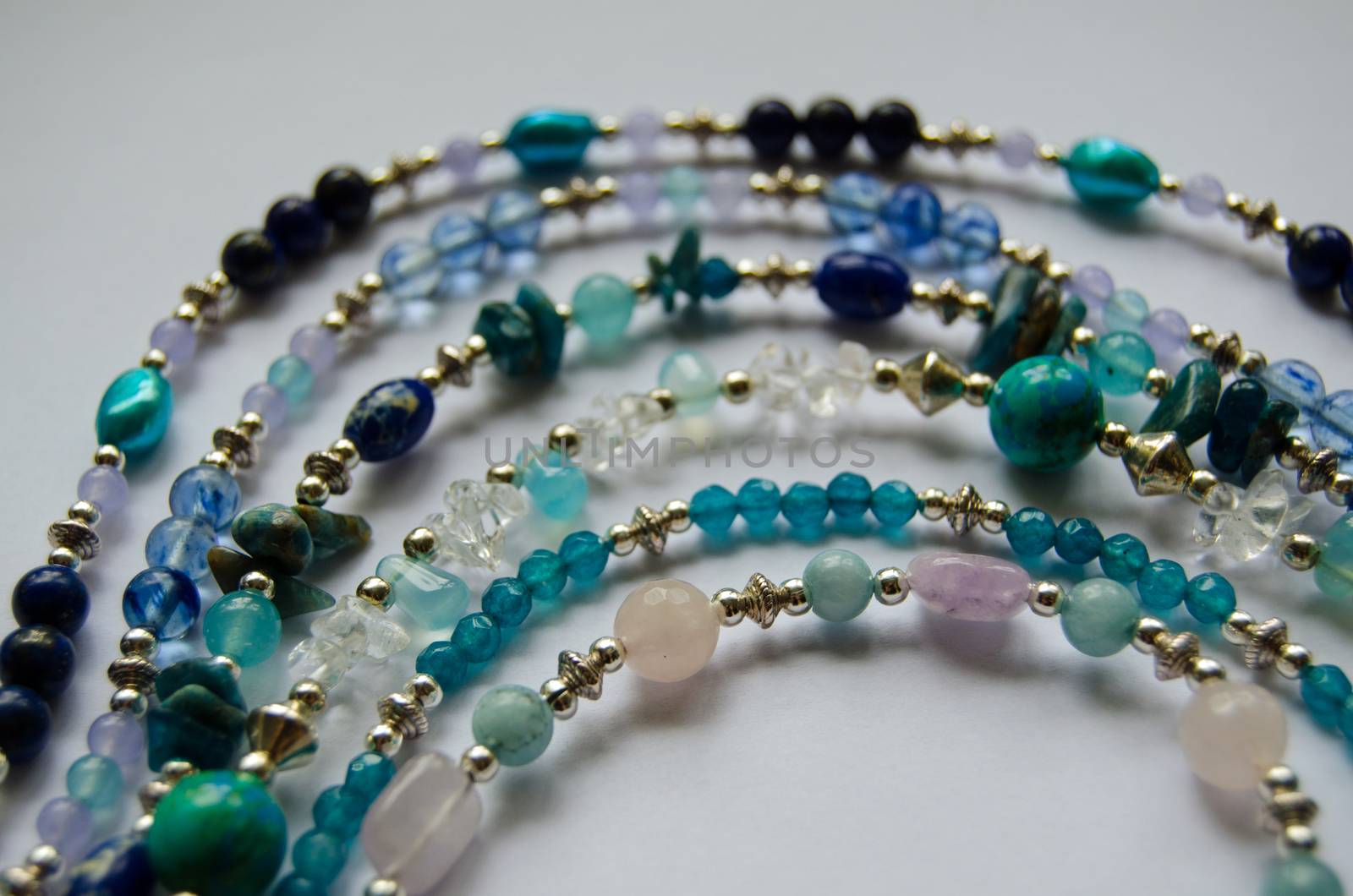 A selection of necklaces made from semi-precious gemstones including rose quartz, jasper, apatite, amethyst, lapis lazuli and pearls.  Various beads separated with silver plated beads.  