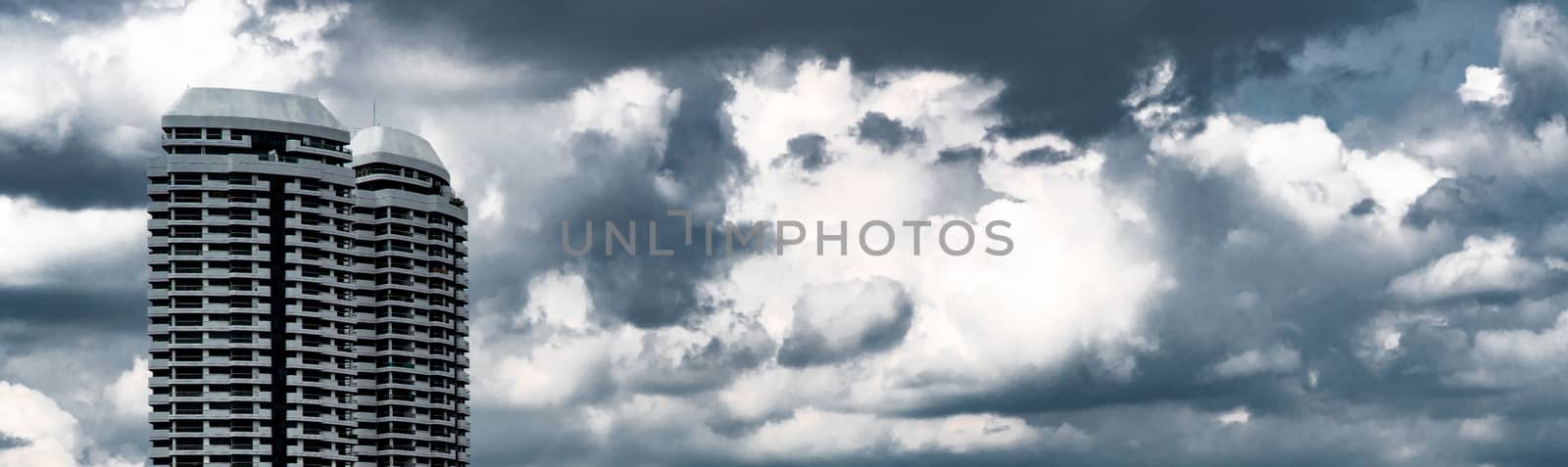High-rise building with grey sky and white clouds. Commercial bu by Fahroni