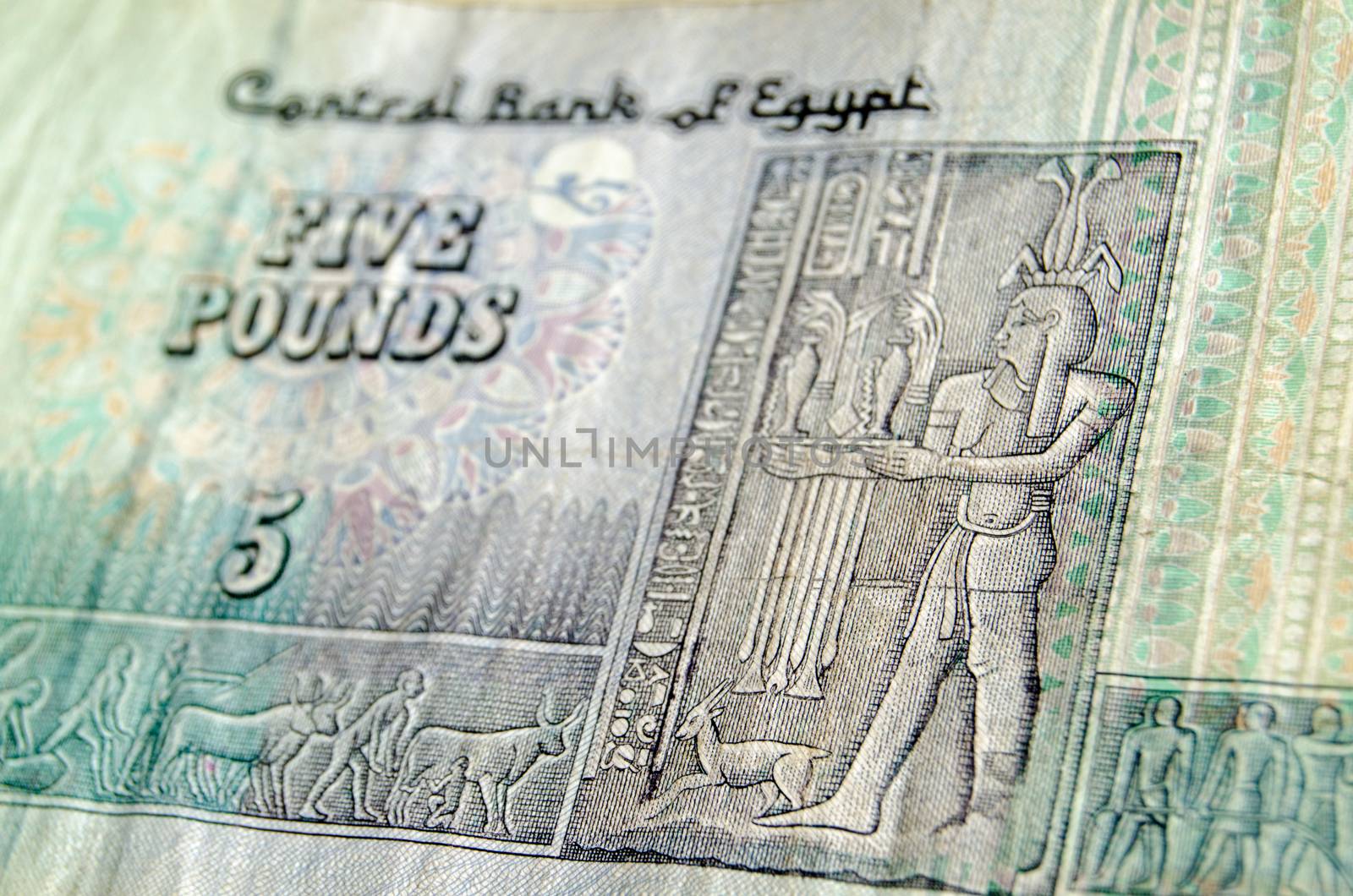 The Ancient Egyptian god Hapi, representing the bounty of the Nile, on the front of a five pound banknote from Egypt.  Used banknote, photographed at an angle.