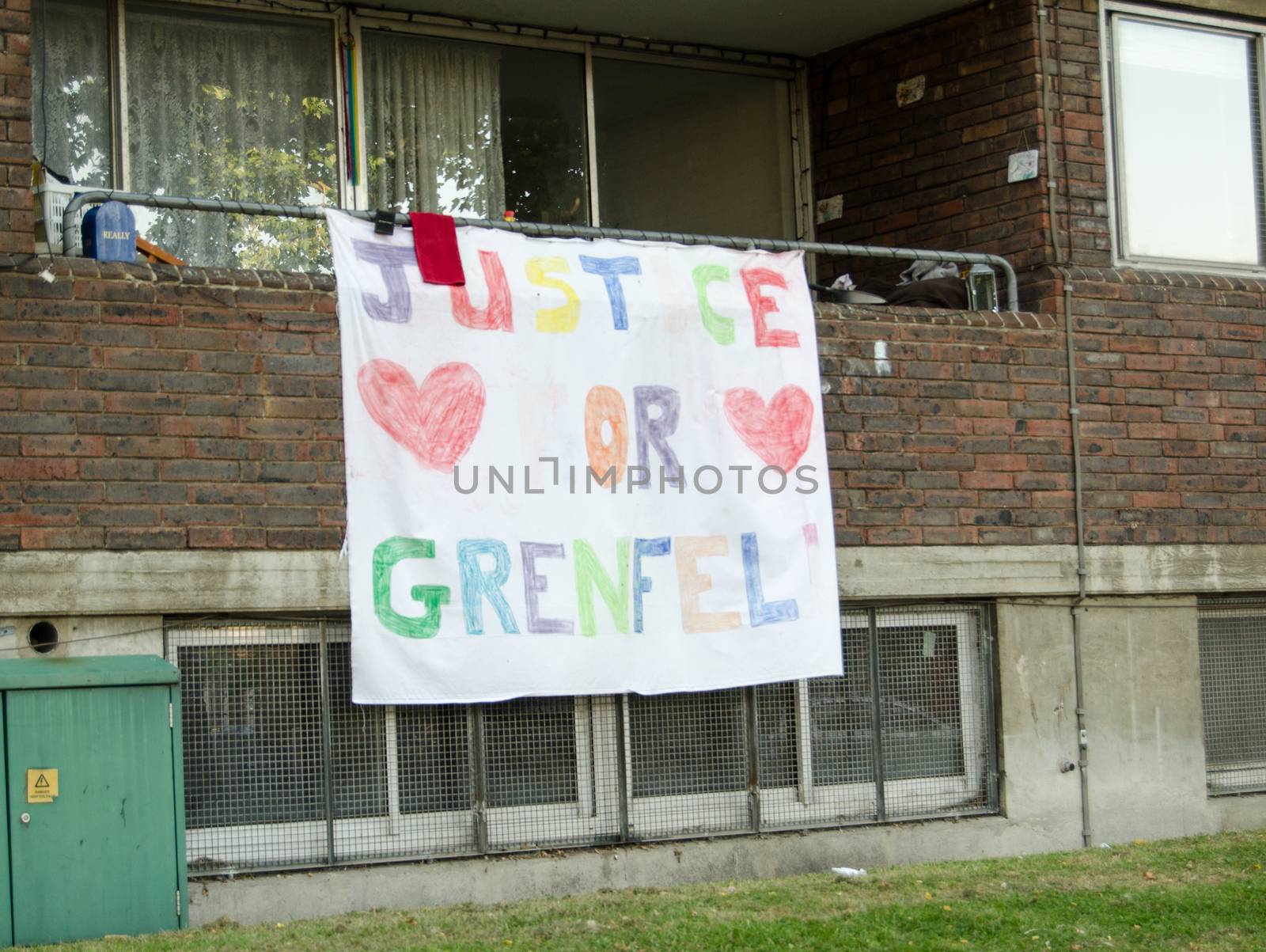Hand drawn banner calling for Justice for Grenfell displayed on the balcony of a flat next to the Grenfell Tower block in which at least 80 people were killed in a fire, Kensington, London.  