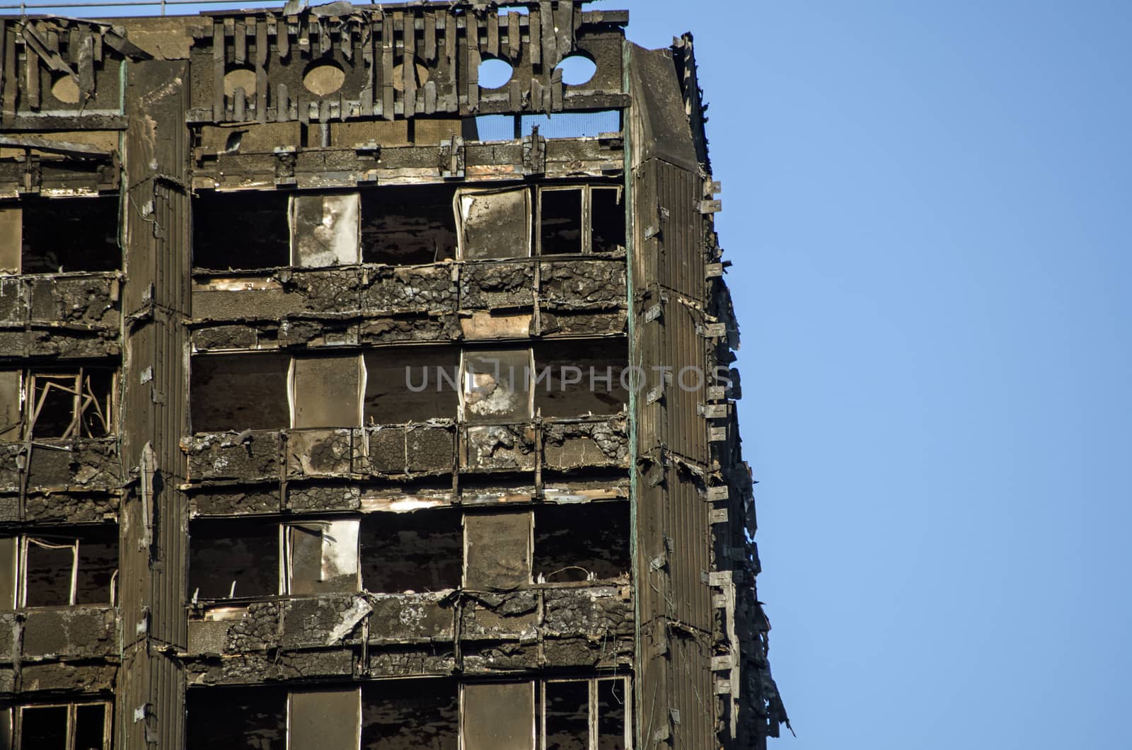 LONDON, UK - JULY 5, 2017: Part of the top floors of the Grenfell Tower block of council flats in which at least 80 people are thought to have been killed following a fire in Kensington, West London.