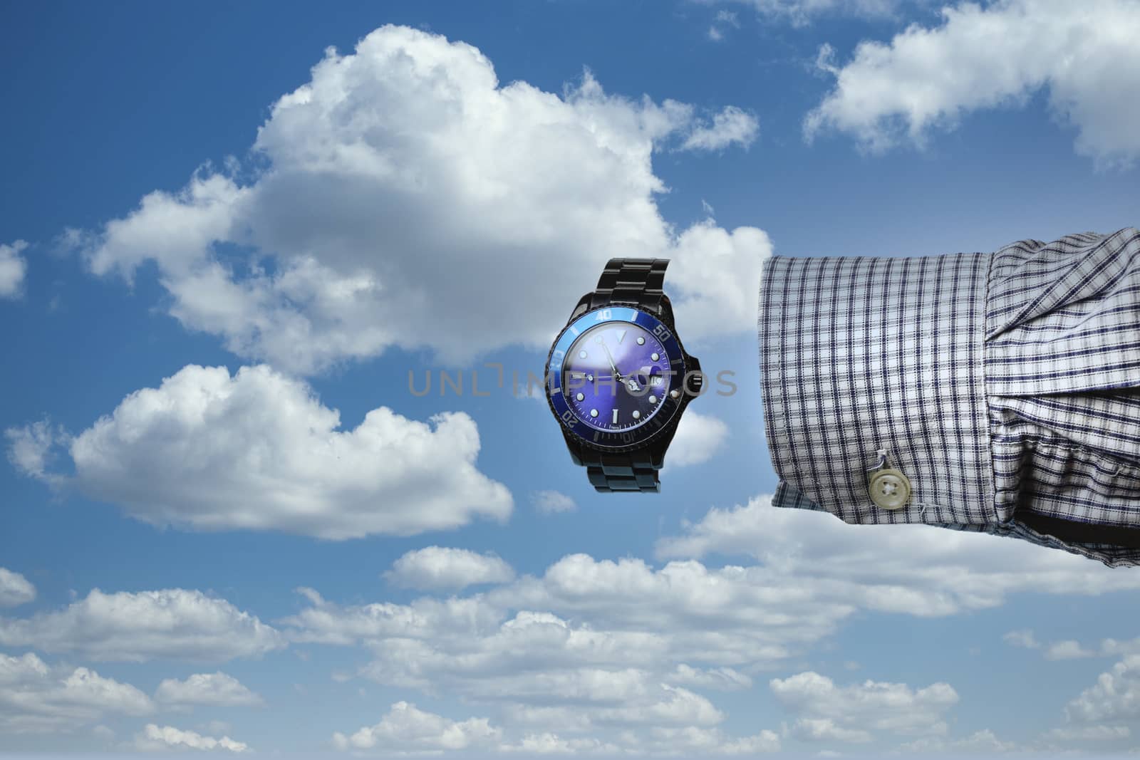 the sleeve of a shirt and a clock with no hand with the cloudy sky in the background