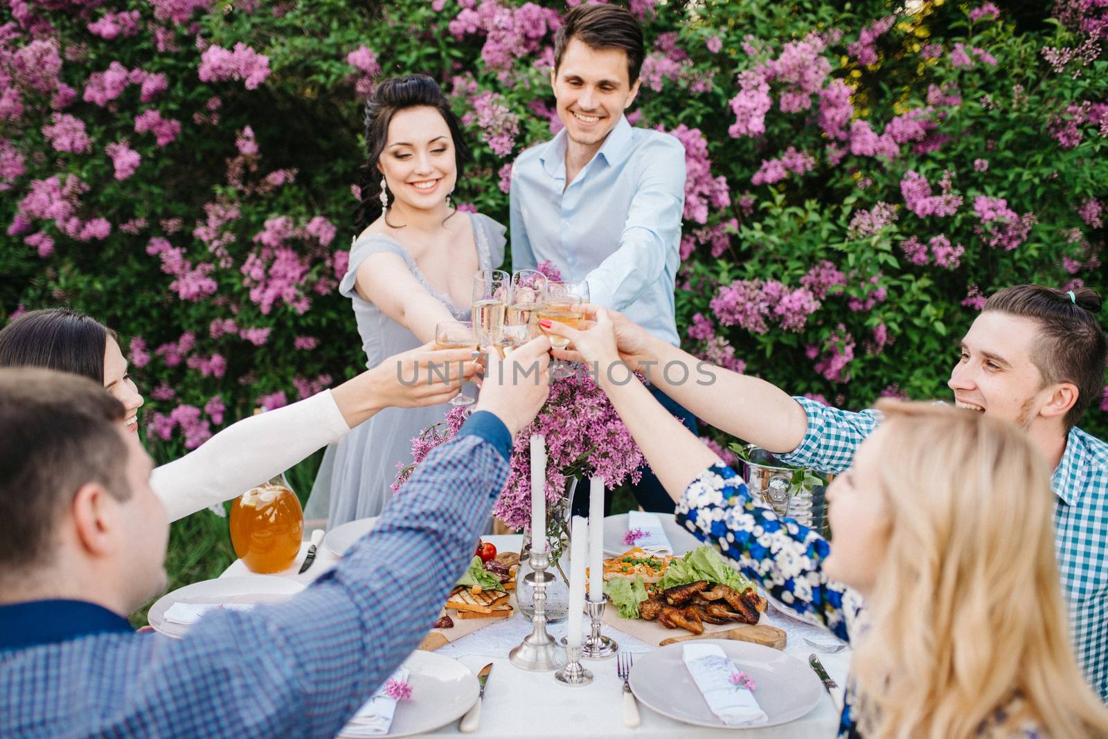 bride and groom at a wedding table with friends in a spring garden