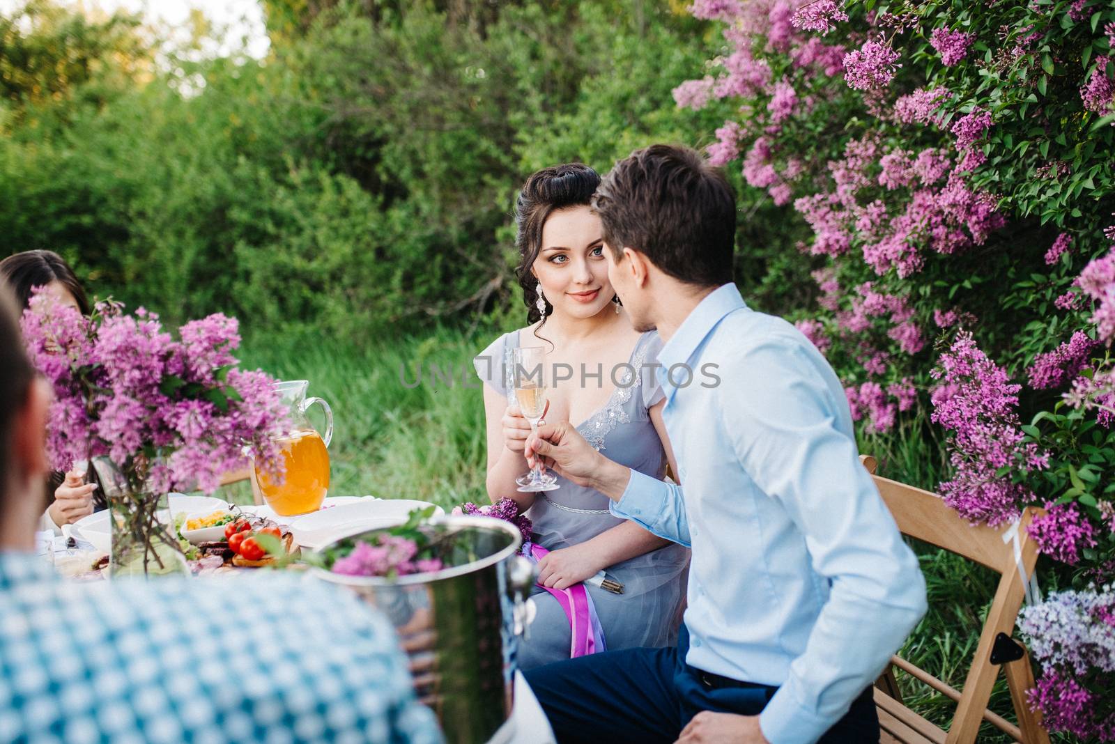 bride and groom at a wedding table with friends in a spring garden