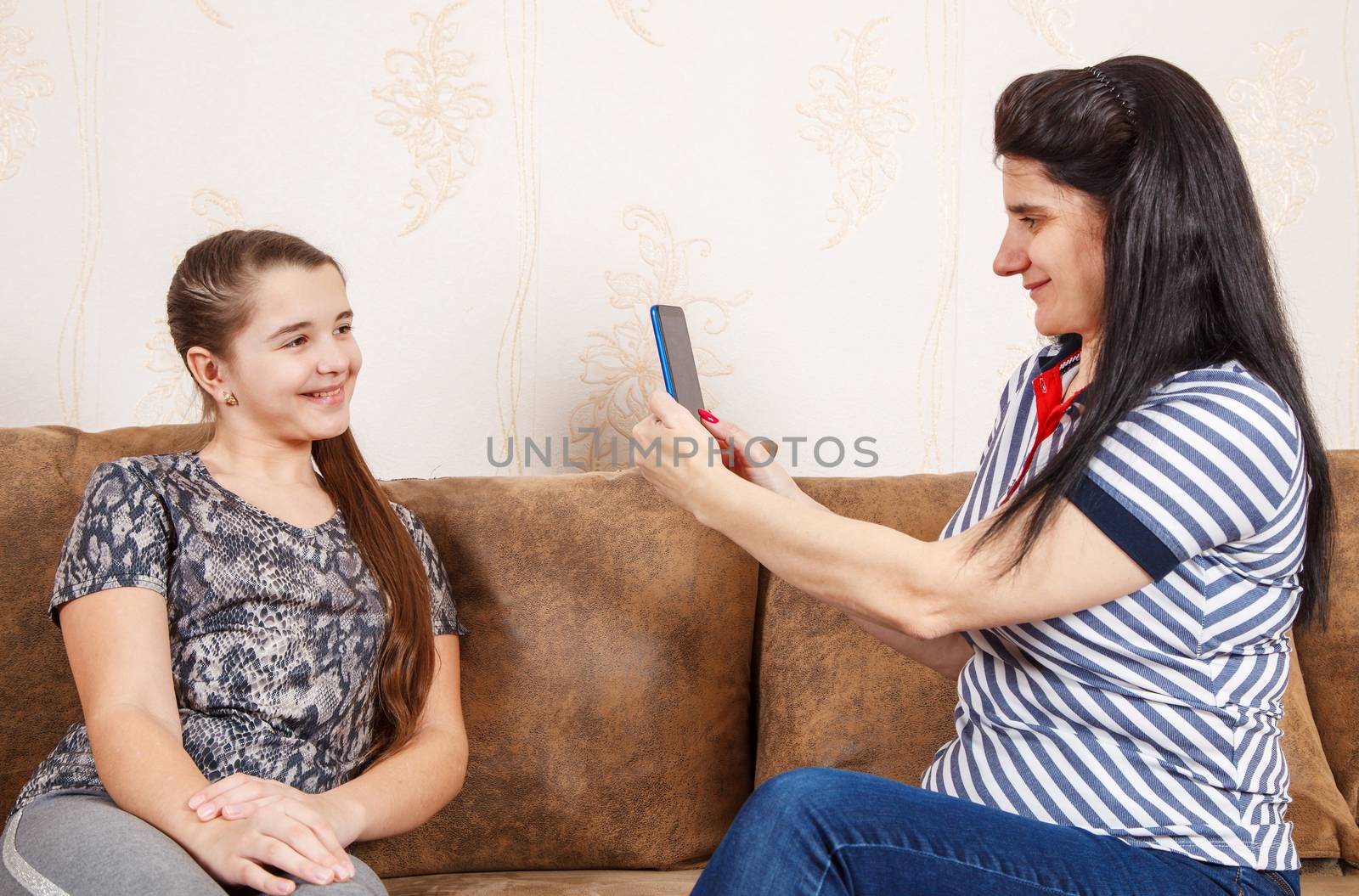 mom photographs daughter with a smartphone by raddnatt